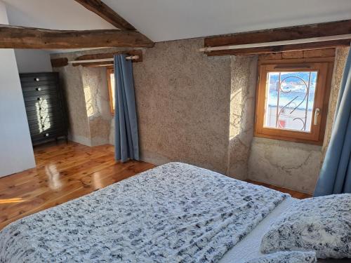 1 dormitorio con cama y ventana en Le Grenier des Moineaux, en Odeillo-Via
