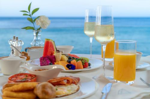 a table with plates of food and glasses of wine at Lani's Suites de Luxe - Adults Only in Puerto del Carmen
