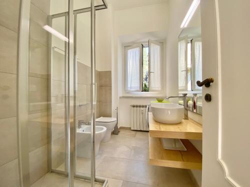 y baño con ducha de cristal y aseo. en CasaViva-Stylish Trilo with AC-shared pool-parking en Génova