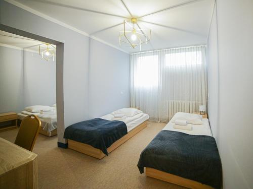 um quarto com 2 camas individuais e um espelho em Izabella em Puławy