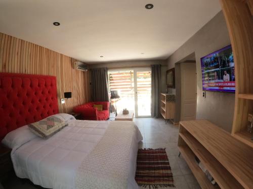 1 dormitorio con 1 cama grande con cabecero rojo en Departamento con parque a metros del mar en Ostende