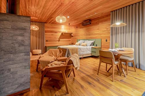 um quarto com uma cama, uma mesa e cadeiras em Refúgio de Altitude em Urupema