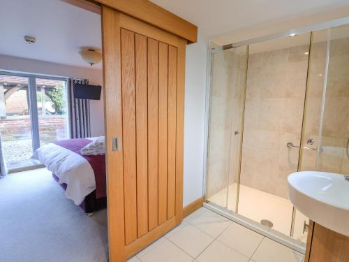 a bathroom with a shower and a bed and a sink at Servant's Quarters in York