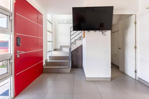 a hallway with a red door and a tv on a wall at #CasaMare - Privada a una cuadra del mar con AC in Ensenada