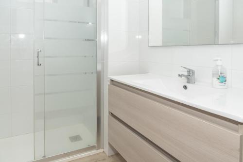 ein weißes Bad mit einem Waschbecken und einer Dusche in der Unterkunft Las Vegas, Esc-1, 4-8 in Cullera