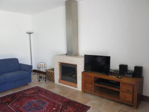 a living room with a tv and a fireplace at Sea wave sounds, Meco, by the beach in Sesimbra