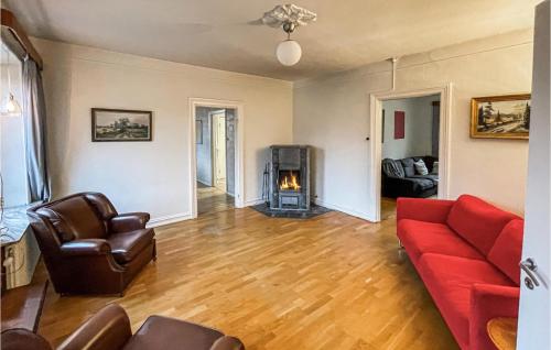 a living room with a red couch and a fireplace at 4 Bedroom Lovely Home In Södra Sandby in Södra Sandby
