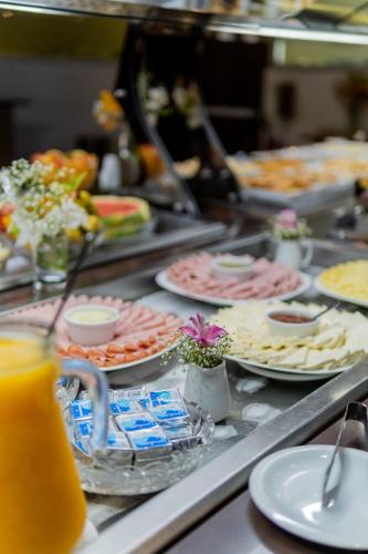 a buffet line with plates of food and drinks at Paradiso Corporate in Cabo Frio