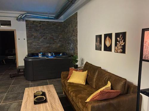 a living room with a brown couch and a tub at Residence Pasteur Angouleme in Angoulême
