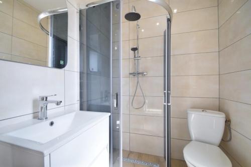 een badkamer met een douche, een toilet en een wastafel bij Apartamenty u Hanysa in Niechorze