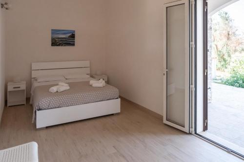una camera con letto e porta scorrevole in vetro di agriturismo masseria pallanzano a Otranto
