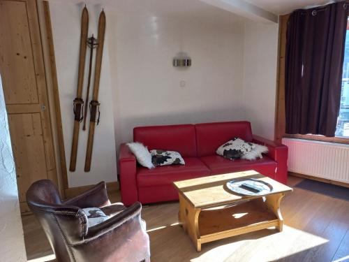 un salon avec un canapé rouge et une table dans l'établissement Appartement rénové 2 pièces, pied des pistes, balcon sud, Tignes - FR-1-449-30, à Tignes