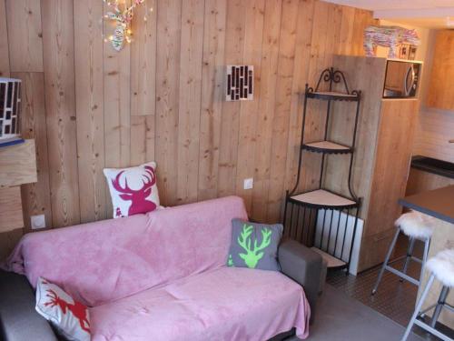 a living room with a pink couch and a wooden wall at Studio Tignes, 1 pièce, 4 personnes - FR-1-449-52 in Tignes