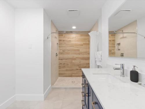 uma casa de banho com um chuveiro e uma porta de madeira em New 4 Bedroom Villa W Private Backroom, Pool em Pembroke Pines