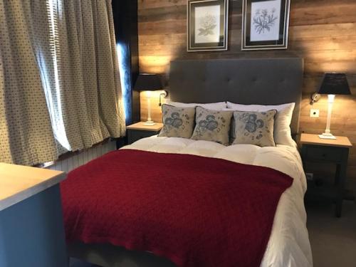 a bedroom with a large bed with a red blanket at 3 pièces au pied des pistes avec balcon et WIFI à Tignes - FR-1-449-50 in Tignes