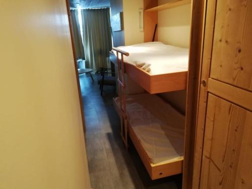 Cette chambre comprend 2 lits superposés et un couloir. dans l'établissement 2 pièces au pied des pistes avec parking inclus et balcon exposé Sud-Ouest - FR-1-449-57, à Tignes