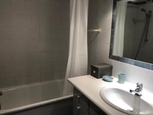 ein Badezimmer mit einem Waschbecken, einer Badewanne und einem Spiegel in der Unterkunft Appartement Tignes, 2 pièces, 5 personnes - FR-1-449-76 in Tignes