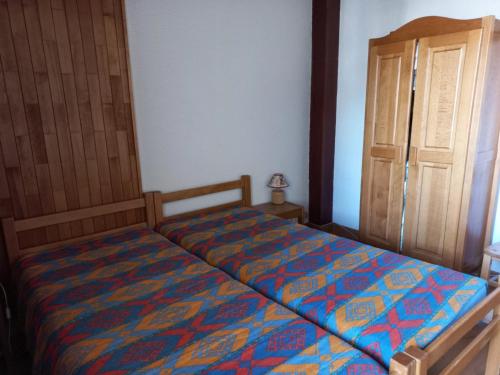 - une chambre avec un lit et une porte en bois dans l'établissement Duplex 4 pièces, balcon Sud/Ouest, 100m des pistes - FR-1-449-94, à Tignes