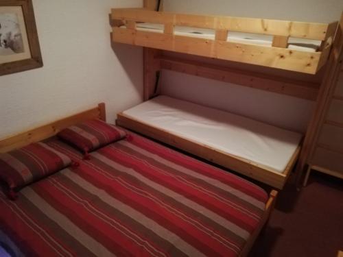 Cette petite chambre comprend deux lits superposés et un lit. dans l'établissement Appartement 2 Pièces Sud/Ouest, Balcon, à 100m des Pistes - Tignes Val-Claret - FR-1-449-93, à Tignes
