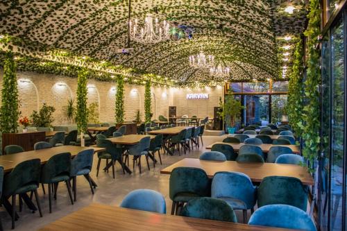 une salle à manger avec des tables, des chaises et des lumières dans l'établissement Karvan Qusar, à Qusar