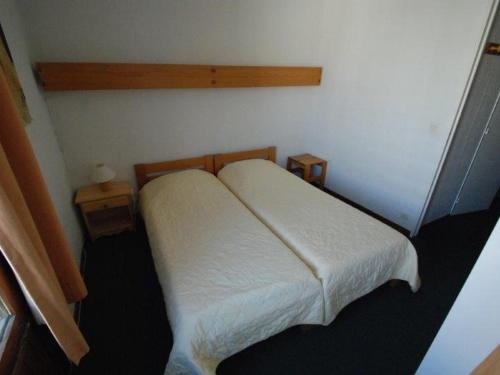 - une chambre avec un lit blanc et 2 tables dans l'établissement Charmant 2 pièces, balcon sud/ouest, coeur de Tignes, Wi-Fi, proche commerces - FR-1-449-148, à Tignes