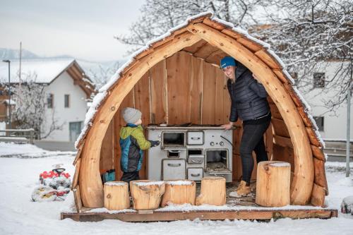a man and a child standing inside of a wooden play house at Stadl Chalet oberhalb Brixen in Rosa