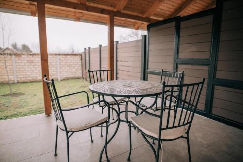una mesa de patio y sillas en un porche en Tulip Guest House II. en Palić