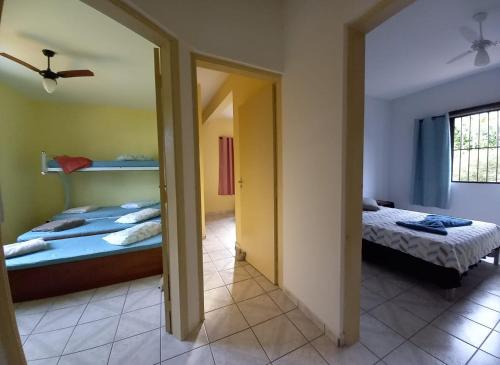 a bedroom with two beds and a mirror at Recanto da praia in Bertioga
