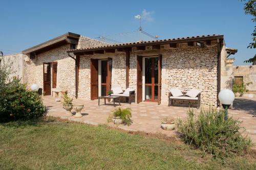 una casa de piedra con un patio frente a ella en Agriturismo Masseria Pallanzano, en Otranto