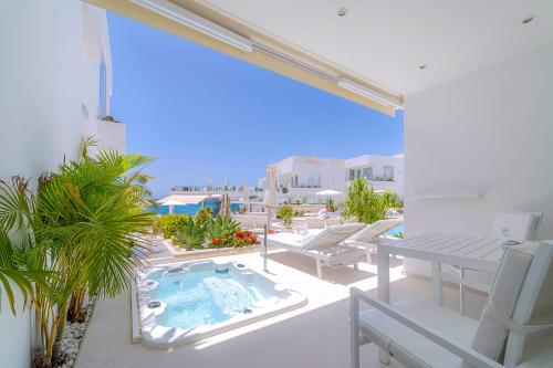 a balcony with a swimming pool and a table and chairs at Lani's Suites de Luxe - Adults Only in Puerto del Carmen