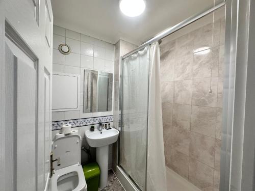 La salle de bains est pourvue de toilettes, d'un lavabo et d'une douche. dans l'établissement Posh 2-Bedroom, Living Room, Kitchen & 1.5 Bathroom, à Londres