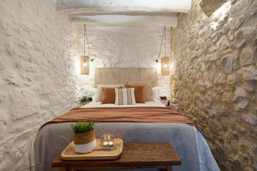 a bedroom with a bed in a stone wall at El Pajar de Jafre , Costa Brava Empordà 