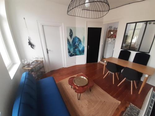 un salon avec un canapé bleu et une table dans l'établissement Amiens magnifique appartement Frida, à Amiens
