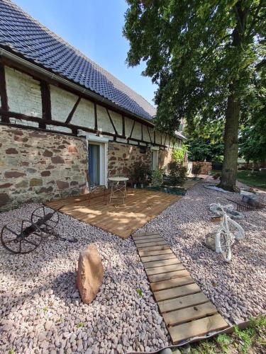 un patio trasero con una pasarela de madera junto a un edificio en Chambre indépendante n3 - Bretzel et Bergamote, en Richtolsheim
