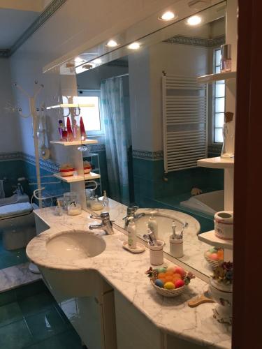 a bathroom with a sink and a large mirror at B&B DONNA PORZIA in Trani