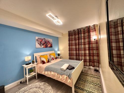 - une chambre avec un lit et un mur bleu dans l'établissement Posh 2-Bedroom, Living Room, Kitchen & 1.5 Bathroom, à Londres