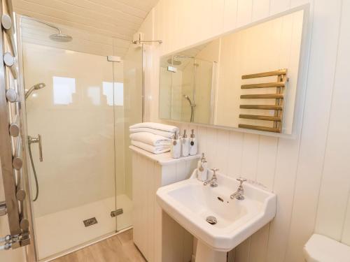 a white bathroom with a sink and a shower at The Storyteller in York