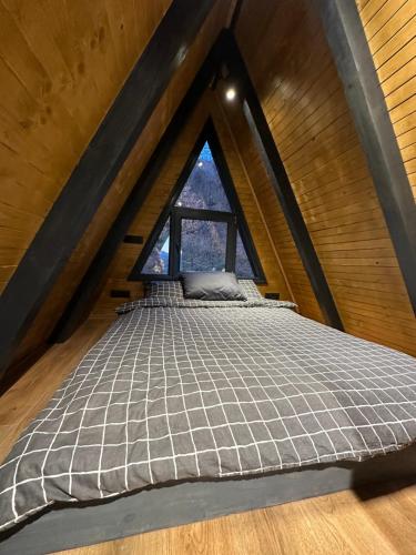 a bed in a room with a window at Loon Moon Mountain Chalets in Sarajevo