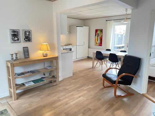 a living room with a table and chairs and a kitchen at Skjernaa-ferie/ Andersen Invest in Skjern