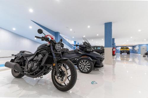 two motorcycles parked in a room with a car at Lani's Suites de Luxe - Adults Only in Puerto del Carmen