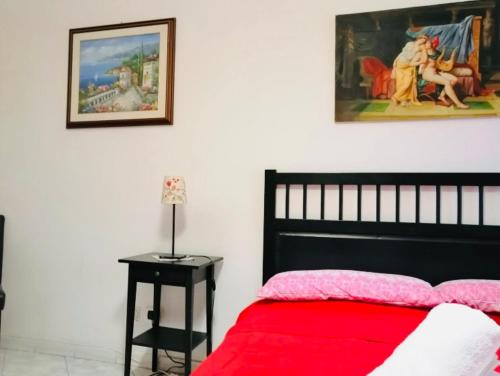 a bedroom with a red bed and a painting on the wall at Casa Mirandola in Rome