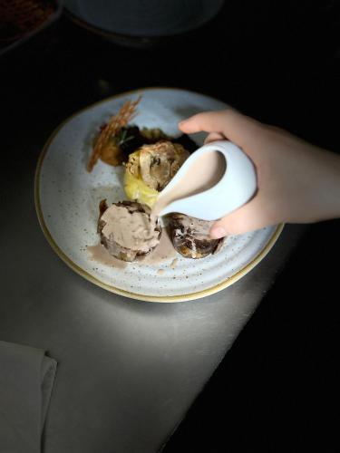 a person holding a spoon over a plate of food at O frances in Nelas