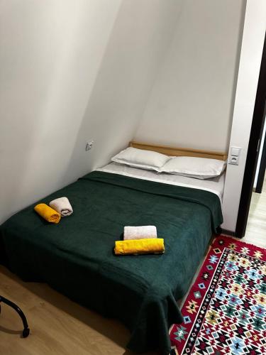 a bedroom with a green bed with two towels on it at LUMA Sadgeri (Borjomi) in Borjomi