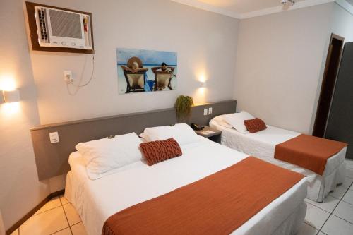 Giường trong phòng chung tại Camboriú Praia Hotel