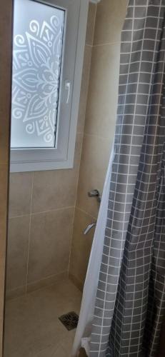 ducha con ventana y cortina de ducha en Monoambiente El Otto en San Carlos de Bariloche