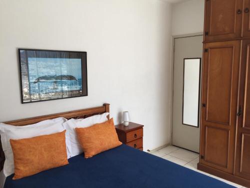 a bedroom with a blue bed with orange pillows at Barra Palace in Rio de Janeiro