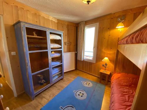 - une chambre avec des lits superposés et une table bleue dans l'établissement 3 pièces rénové S/O, 2 balcons, wifi, commerces - FR-1-449-2, à Tignes