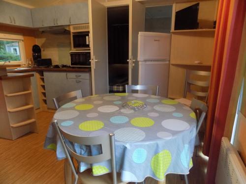 una cucina con tavolo e tovaglia a pois di Mobil-home 6 personnes 3 chambres a La Boissière-de-Montaigu