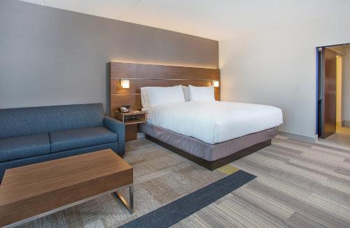 コビントンにあるHoliday Inn Express & Suites Covington, an IHG Hotelのベッドとソファ付きのホテルルーム