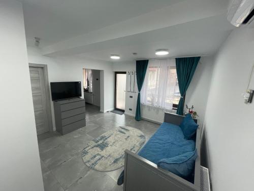 a living room with a blue couch and a television at Apusului Residence in Bucharest